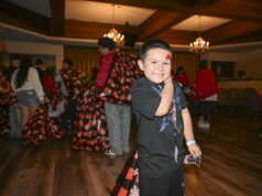 SBCSS Brings Holiday Joy to Youth Experiencing Homelessness A young boy smiles at the camera after receiving a tote filled with gifts during the 21st Annual SBCSS CDS Holiday Celebration on December 18.