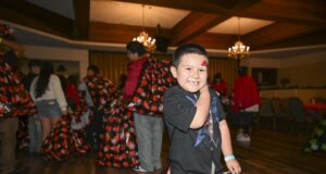 SBCSS Brings Holiday Joy to Youth Experiencing Homelessness A young boy smiles at the camera after receiving a tote filled with gifts during the 21st Annual SBCSS CDS Holiday Celebration on December 18.