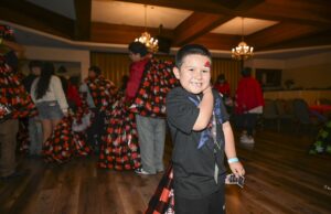 SBCSS Brings Holiday Joy to Youth Experiencing Homelessness A young boy smiles at the camera after receiving a tote filled with gifts during the 21st Annual SBCSS CDS Holiday Celebration on December 18.