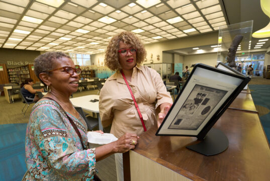 Black Californians Invited to Share Their Stories Through New Community Oral History Initiative Exhibit curator Kellie Todd Griffin shares the Museum of Black Women and Girls Pop-Up with an oral history project participant at the A C Bilbrew Library.