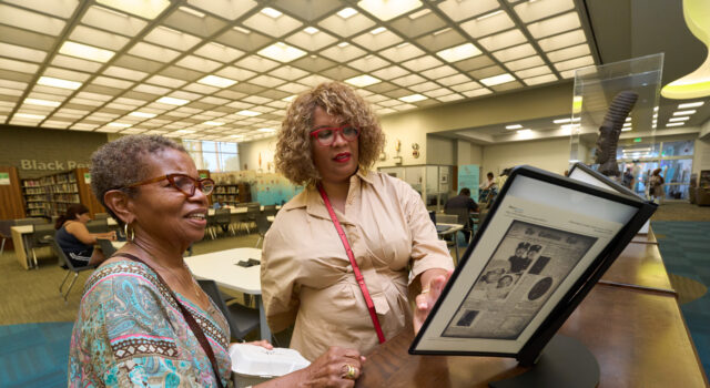 Black Californians Invited to Share Their Stories Through New Community Oral History Initiative Exhibit curator Kellie Todd Griffin shares the Museum of Black Women and Girls Pop-Up with an oral history project participant at the A C Bilbrew Library.